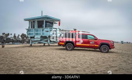 Californie, États-Unis, 28 septembre 2024, vue d'une tour de sauveteur et d'une camionnette rouge sur la plage de Santa Monica par un jour couvert Banque D'Images