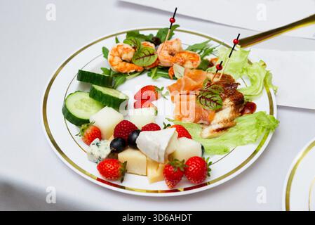 Un plat magnifiquement arrangé avec des fruits de mer frais, assortiment de fromages et fruits vifs. parfait pour les repas gastronomiques ou les événements de restauration, offrant Banque D'Images