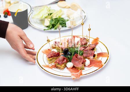 Un plateau de hors-d'œuvre magnifiquement arrangé avec une variété d'articles antipasto tels que des charcuteries, des olives et du fromage. parfait pour les dîners Banque D'Images
