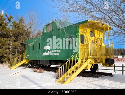 NISSWA MN - 24 décembre 2021 : le caboose de train vert avec garniture jaune le jour ensoleillé d'hiver est une attraction touristique dans le Minnesota. Banque D'Images
