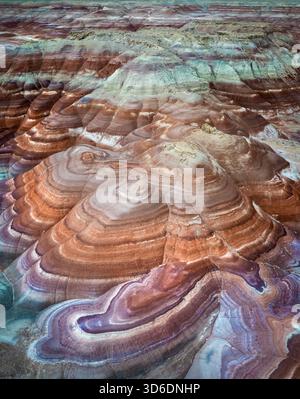 Vue aérienne de couches vibrantes et tourbillonnantes de terre dans les tons de rouge, orange, blanc et sarcelle créent un paysage fascinant et texturé, Hanksville, Utah, Banque D'Images