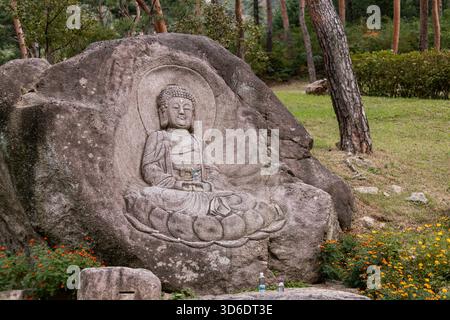 Pierre avec l'image de Bouddha sculpter assis dans la fleur de lotus dans le temple sud-coréen Banque D'Images