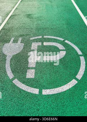 Symbole peint sur le sol dans une aire de stationnement d'une station de recharge pour véhicules électriques Banque D'Images