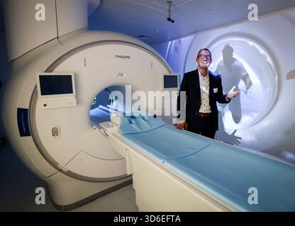 20 novembre 2025, Hambourg : Uwe Heckert, Président du Directoire de Philips GmbH et leader du marché Philips DACH, se tient devant un appareil IRM Philips Ingenia Elition 3,0 Tesla avec une animation vidéo de football sur le mur dans une salle d'examen de l'Athleticum am Volkspark. Après des années de travaux de planification et de construction, l’Athleticum am Volkspark a été officiellement inauguré jeudi. Le nouveau centre offre environ 5 000 mètres carrés de diagnostic, de thérapie, de réadaptation et de prévention à la pointe de la technologie pour les athlètes professionnels et récréatifs. Photo : Christian Charisius/dpa Banque D'Images