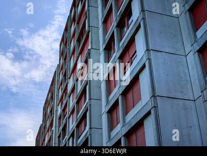 Un bâtiment brutal à Kaiseraugst, en Suisse, présente des volets répétitifs en béton et rouges, évoquant un sentiment de minimalisme, de vie austère Banque D'Images