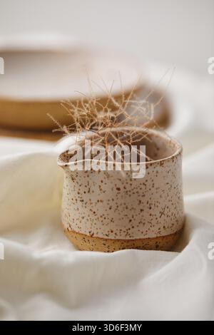 Saucière en céramique sur fond textile blanc. Céramiques faites à la main. Banque D'Images