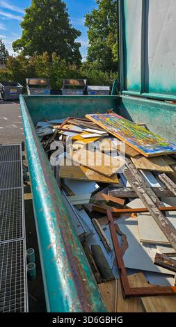 Une grande benne à ordures ouverte remplie de divers déchets de construction et de vieux meubles. Un lieu de collecte et de tri des déchets. Banque D'Images