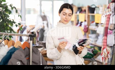 Fille choisit des chaussettes chaudes pour l'hiver dans le magasin de vêtements Banque D'Images