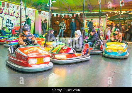 10.09.25. Bad Hersfeld, Allemagne, les enfants conduisent des autos pare-chocs colorés sous des lumières vives du champ de foire. Le mouvement, les couleurs vibrantes et l'atmosphère animée Banque D'Images