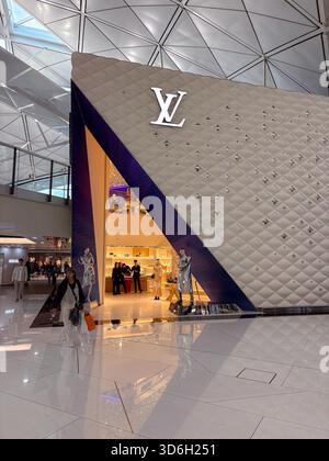 Boutique Louis Vuitton avec son logo emblématique et sa façade à motifs distinctive, située à l'intérieur du terminal contemporain de l'aéroport international de Hong Kong Banque D'Images