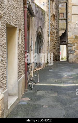 Rue étroite avec de vieilles maisons en pierre naturelle et un vélo garé contre le mur à Saint-Céré Lot Occitanie Sud de la France en été Banque D'Images