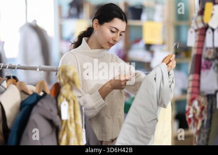 Femme arménienne choisissant des vêtements d'extérieur dans le magasin Banque D'Images