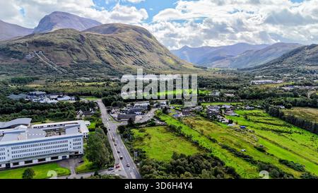 Une vue aérienne ensoleillée de Fort William avec le majestueux Ben Nevis s'élevant en arrière-plan, mettant en valeur le paysage spectaculaire des Highlands de l'Écosse Banque D'Images