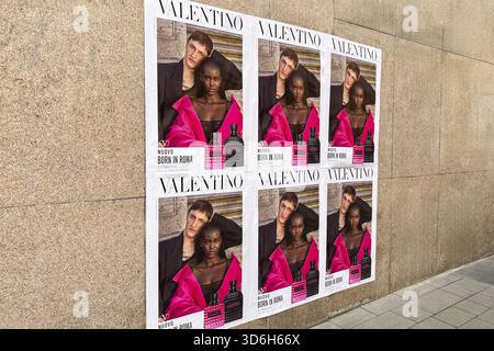 Milan, Italie - 12 avril 2025 : Valentino né à Rome affiches publicitaires avec des modèles sur un mur de pierre à Milan, Italie. Campagne de rue de parfum de luxe Banque D'Images