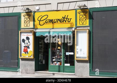 Milan, Italie - 12 avril 2025 : vitrine Comoretto à Milan avec signalisation jaune, affiche Mickey Mouse vintage et vitrine de montres Banque D'Images
