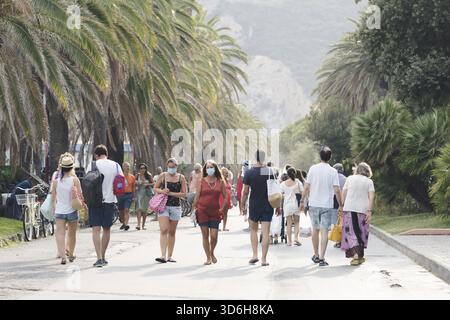 Les gens marchant le long de la plage portent des masques protecteurs ou médicaux. Nouvelle normalité en Italie. Les personnes portant un masque facial et maintiennent la distanciation sociale. Banque D'Images