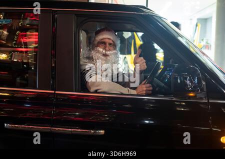 Noël à Londres - Un chauffeur de london Black Cab porte un chapeau de Père Noël et une barbe alors qu'il est assis dans son taxi pendant la période festive, City of London, Angleterre, Royaume-Uni Banque D'Images