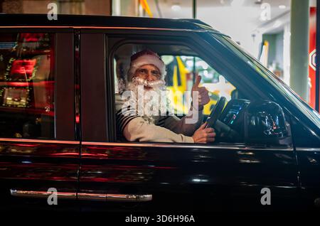Noël à Londres - Un chauffeur de london Black Cab porte un chapeau de Père Noël et une barbe alors qu'il est assis dans son taxi pendant la période festive, City of London, Angleterre, Royaume-Uni Banque D'Images