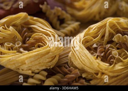 Différents types de pâtes italiennes. Spaghetti, tagliatelle, fusilli, pappardelles, fettuccine. Divers pâtes non cuites faites d'une pâte sans levain o Banque D'Images