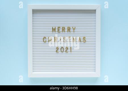 Tableau aux lettres avec message joyeux Noël 2021 sur fond pastel bleu. Composition de Noël. Pose à plat, par le dessus Banque D'Images