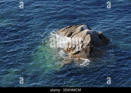 Vagues sur la plage rocheuse, rivage de la mer avec des vagues écrasant sur les grands rochers, journée ensoleillée d'été Banque D'Images