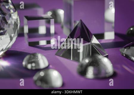 Prisme de cristal réfractant la lumière, les cristaux magiques et la pyramide, la sphère et le cube sur fond violet. Pratique spirituelle de cristal de guérison. Feng Shui, bien Banque D'Images