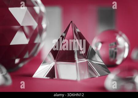 Prisme de cristal réfractant la lumière, les cristaux magiques et la pyramide, la sphère et le cube sur fond violet. Pratique spirituelle de cristal de guérison. Feng Shui, bien Banque D'Images