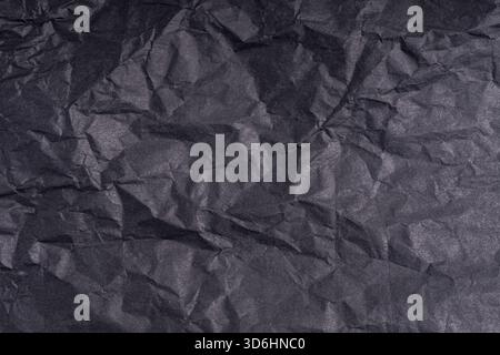 Papier noir froissé foncé texturé de l'affiche. Papier froissé vierge, surface texturée. Carton gringé avec fibre. Gros plan. Banque D'Images