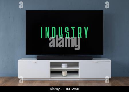 Un téléviseur OLED grand écran affichant le logo de la série télévisée Industry vu dans un salon contemporain. Banque D'Images