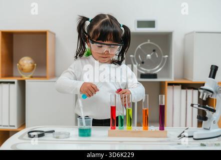 jeune fille scientifique faisant test chimique avec tube à essai et bécher. apprendre les sciences à la maison Banque D'Images