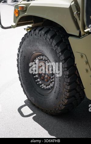 Gros plan de la roue avant du HMMWV. Camion militaire vert lourd avec pneus tout-terrain. Banque D'Images