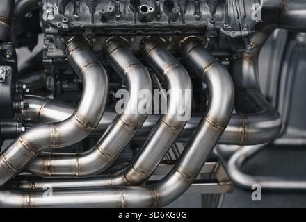 Moteur V8 avec échappement personnalisé. Vue rapprochée de l'échappement du moteur v8 avec barres de coupe personnalisées de même longueur. Vue latérale d'un gros moteur sur un support d'engin. Banque D'Images