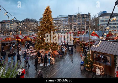 Zurich, Suisse, 20 novembre 2025. Grand arbre de Noël décoré et les gens visitant le marché de Noël Sechselautenplatz. Nuageux en début de soirée Banque D'Images