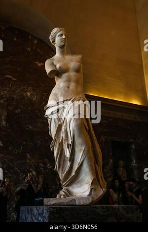 L'ancienne statue grecque Vénus de Milo exposée au Musée du Louvre à Paris, sur fond de marbre sombre dans la galerie de sculptures. Banque D'Images