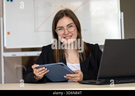 Professeur de mathématiques en ligne devant le tableau blanc avec tablette Banque D'Images