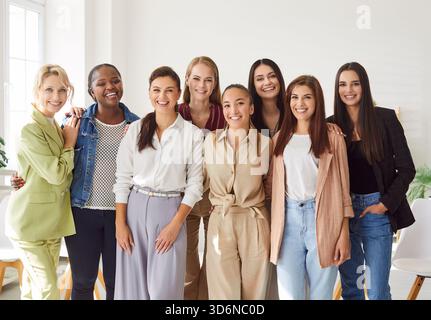 Jeunes femmes portant des vêtements décontractés dans un bureau moderne et regardant joyeux à la caméra. Banque D'Images