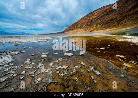 Salines et eaux peu profondes reflétant des nuages spectaculaires dans le bassin de Badwater dans le parc national de la Vallée de la mort. Banque D'Images