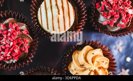 Assiette pleine de beaux mini cupcakes au chocolat coloré avec glaçage vibrant. Parfait pour les fêtes, les célébrations et les tables de desserts. Sucré et délicieux Banque D'Images