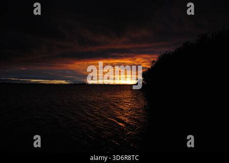 Incroyable jeu de couleurs avec des nuages brûlants au coucher du soleil sur le lac Velence en Hongrie Banque D'Images