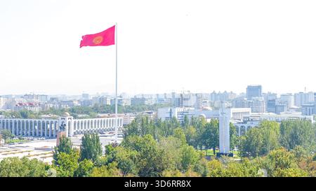 Bichkek, Kirghizistan - 01 octobre 2024 : perspective aérienne du drapeau du Kirghizistan sur la place Ala-Too, mettant en valeur des couleurs vives sur fond urbain et Banque D'Images