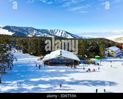 Karakol, Kirghizistan - 13 décembre 2024 : prise de vue aérienne des pistes de ski animées et du Lodge de base en bois, avec une vaste vue panoramique sur la neige enneigée Banque D'Images