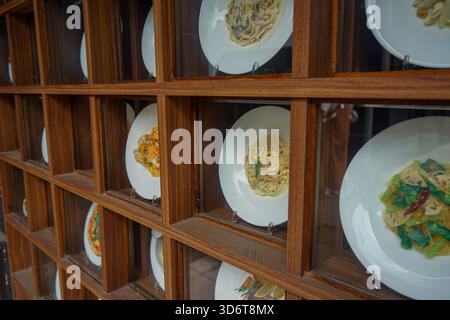 Vue rapprochée de modèles alimentaires japonais, appelés shokuhin sampuru, dans une vitrine devant un restaurant à Nara, au Japon, montrant différents plats de pâtes Banque D'Images