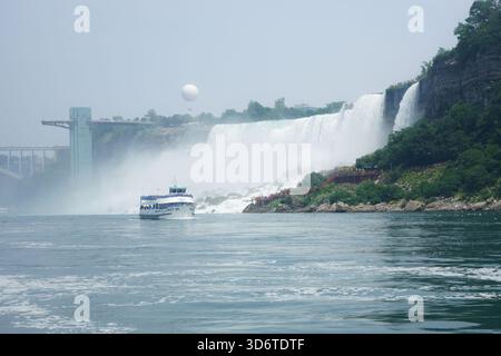 Le bateau de visite Maid of the Mist passe par les chutes américaines sur la rivière Niagara avec la tour d'observation des chutes du Niagara à Niagara Falls, Ontario, Canada Banque D'Images