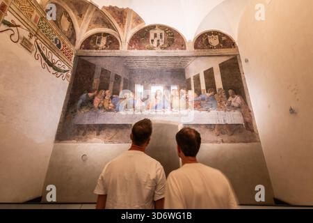 MILAN, ITALIE ? AOÛT 2025 : deux visiteurs se tiennent devant la peinture murale de Léonard de Vinci ?la Cène ? Au réfectoire de Santa Maria delle Grazie à Milan, symbole de la Renaissance considérée Banque D'Images