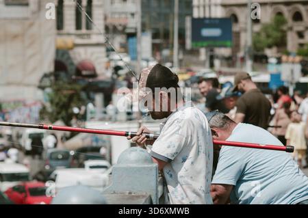 Vie de rue Istanbul pêcheur fumant sur le pont de galata avec fond flou de ville Banque D'Images