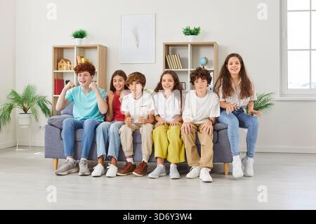 Heureux preteen amis regardant la télévision ensemble, acclamant l'équipe de football préférée et célébrant des objectifs. Banque D'Images