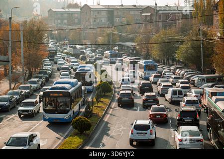 Une rue animée avec un bus et de nombreuses voitures. La scène est chaotique et encombrée Banque D'Images