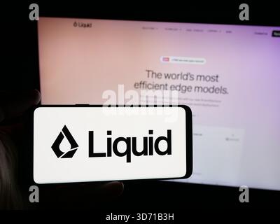 Dans cette illustration photo, une personne tient un smartphone avec le logo de la société américaine d'intelligence artificielle Liquid ai sur l'écran devant le site Web. (Photo timon Schneider / SOPA images/SIPA USA) *** strictement à des fins éditoriales *** Banque D'Images