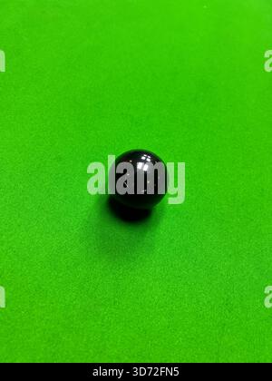 Une balle de snooker noire en cours de réalisation. Banque D'Images