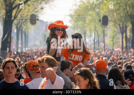 Amsterdam, pays-Bas - 26.04.2025 : les gens portés en orange flottant dans des bateaux près des canaux d'Amsterdam le jour du Roi. Banque D'Images